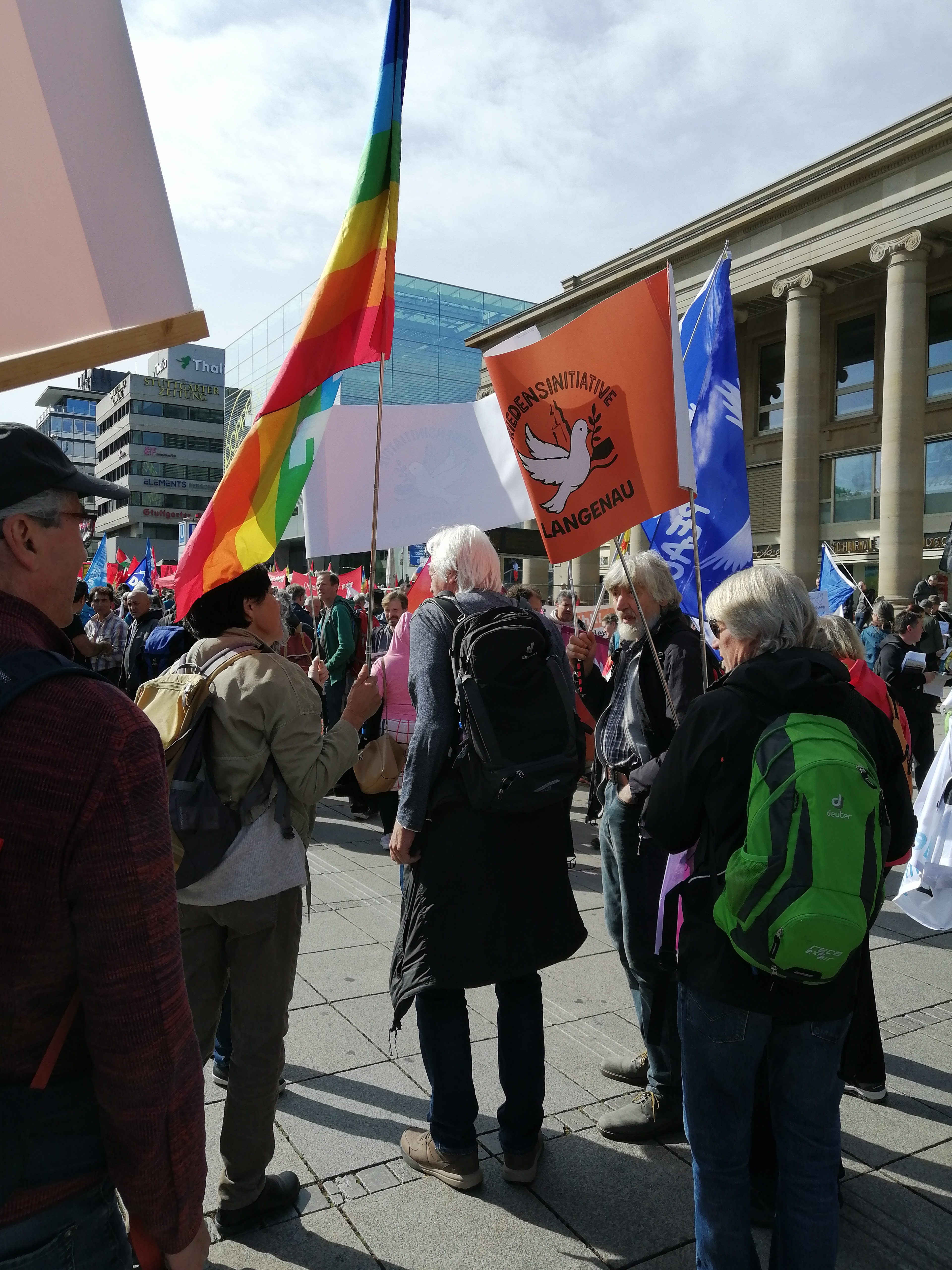 Mitglied der Friedensinitiative Langenau hält die orangefarbene Vereinsfahne bei einer Friedenskundgebung in Stuttgart